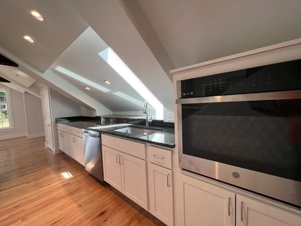 a kitchen with granite countertop a stove and a microwave