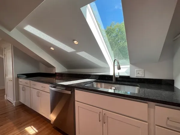 a kitchen with granite countertop a sink and a stove