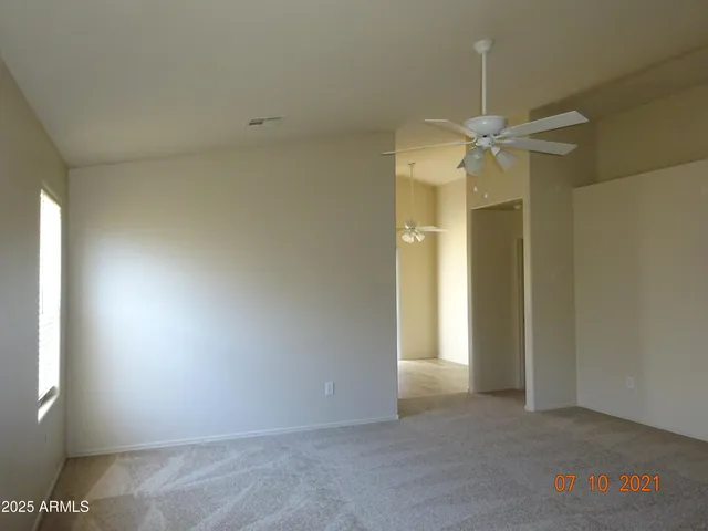 en empty room with windows and ceiling fan
