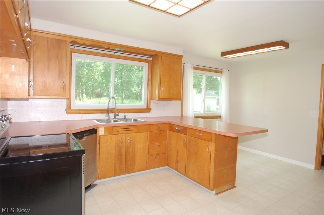 1299 State Road Vermilion, OH 44089 - Photo 16 of 36 Kitchen with plenty of natural light, kitchen peninsula, electric range oven, and light tile patterned floors