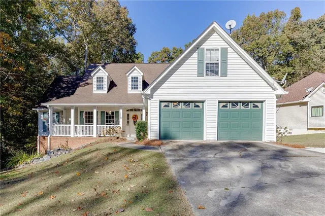 a front view of a house with a garden and trees