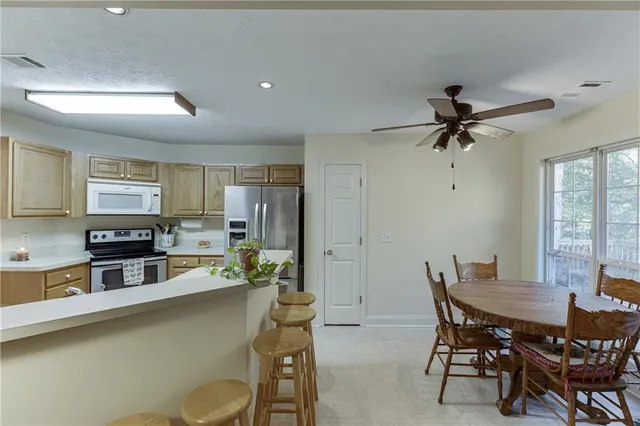 a kitchen with a table chairs refrigerator and cabinets