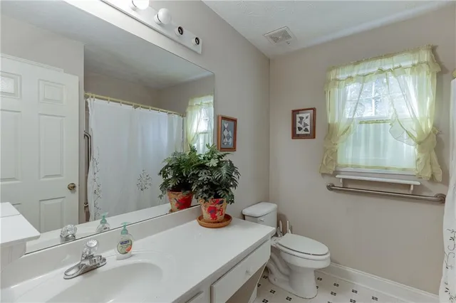 a bathroom with a granite countertop sink mirror and toilet