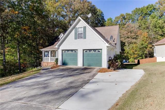 a view of a house with a yard and large tree