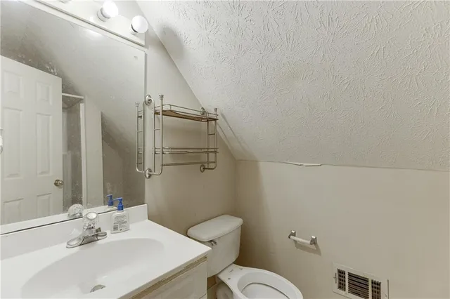 a bathroom with a sink mirror vanity and toilet