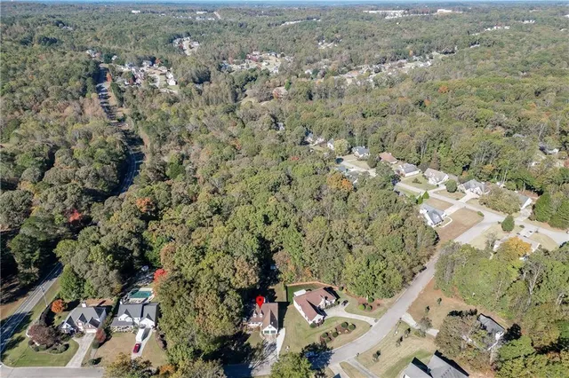an aerial view of a house with a yard and mountain view in back