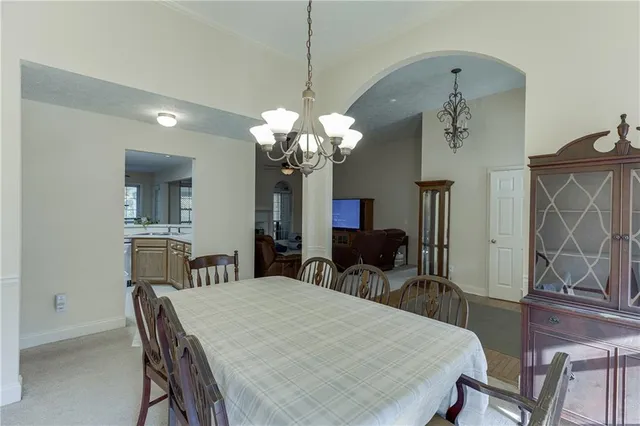 a dining room with furniture a chandelier and wooden floor