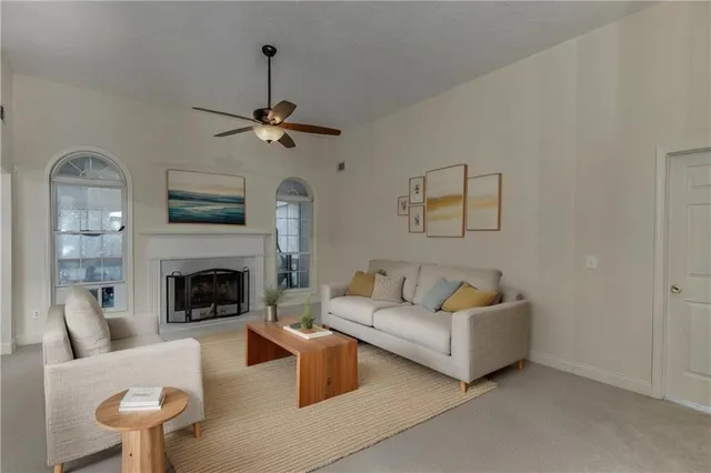 a living room with furniture a fireplace and a chandelier