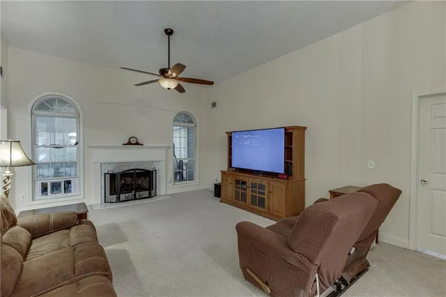 a living room with furniture a fireplace and a chandelier