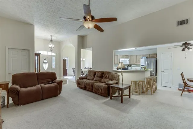 a living room with furniture and a view of kitchen