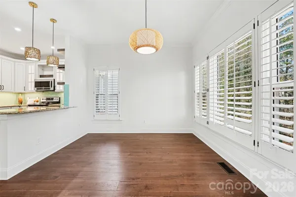 a spacious bathroom with a double vanity sink a large mirror a bathtub and next to a window