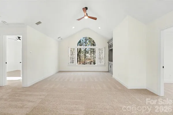 an empty room with a ceiling fan and window
