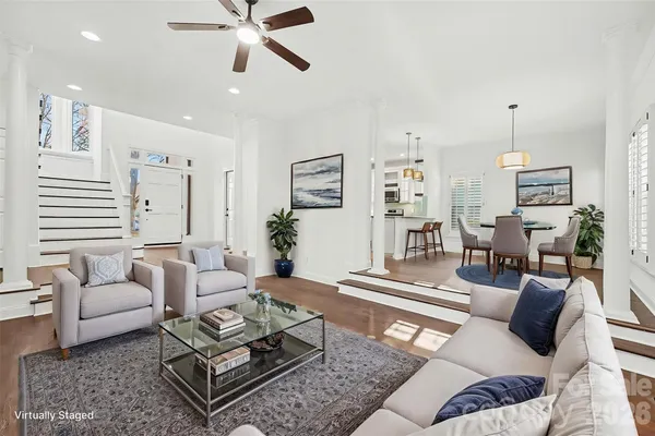 a view of an empty room with wooden floor fireplace and a window