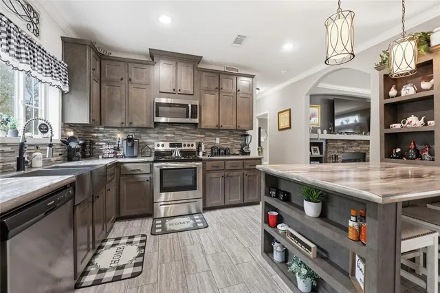 a table with a stove and kitchen view with wooden floor