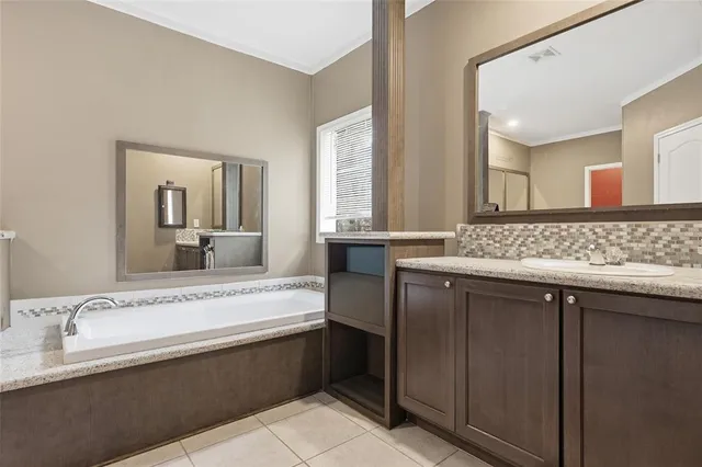 a bed sitting in a bedroom next to a bathroom