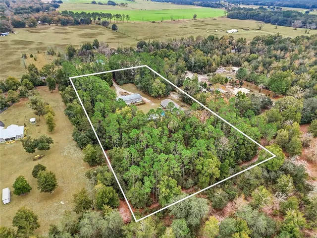 a view of a house with a swimming pool and yard
