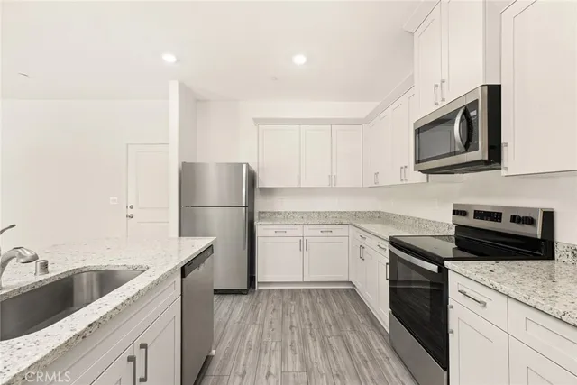 a kitchen with sink a microwave and cabinets