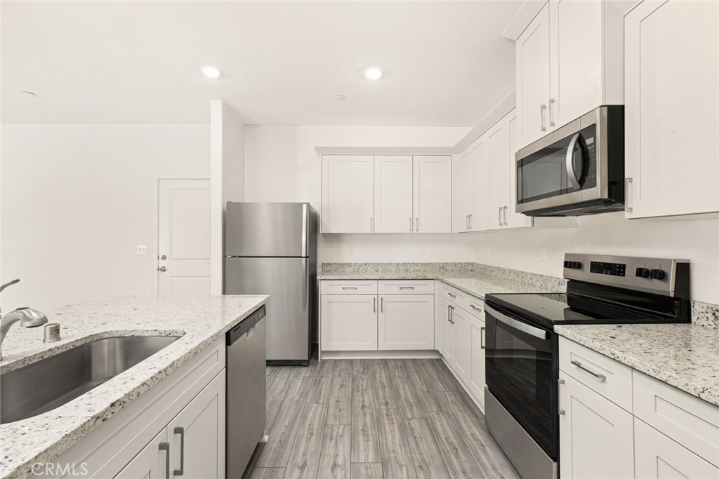 42499 Aruba Court Indio, CA 92201 - Photo 7 of 22 a kitchen with sink a microwave and cabinets