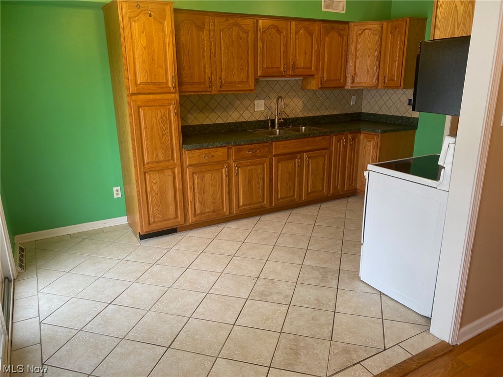 Kitchen with room for table and chairs, ceramic tile floor and backsplash