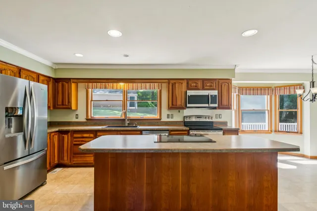 a kitchen with stainless steel appliances a large window and a refrigerator
