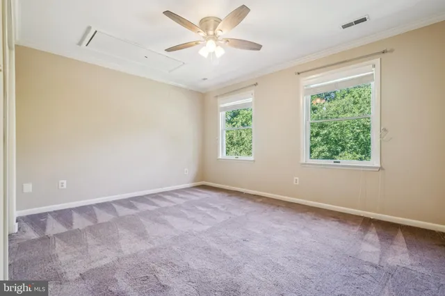 an empty room with closet and a chandelier fan