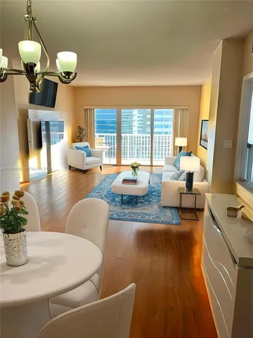 a living room with fireplace furniture and a large window