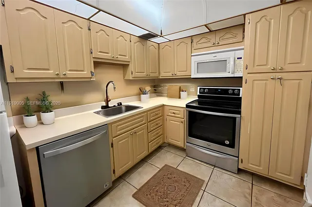 a kitchen with stainless steel appliances granite countertop a sink a stove a refrigerator and cabinets