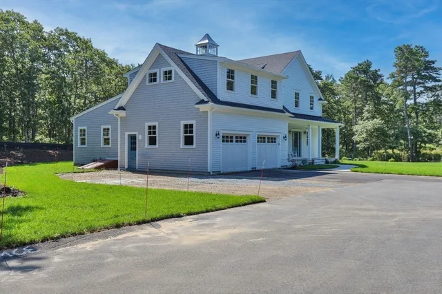 a view of a house with a yard and large tree