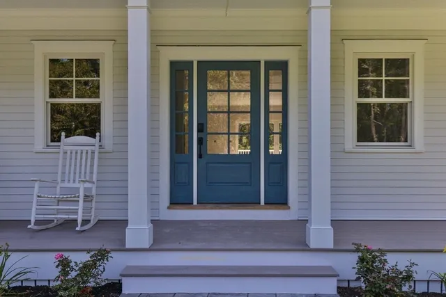 a front view of a house with a window and potted plants