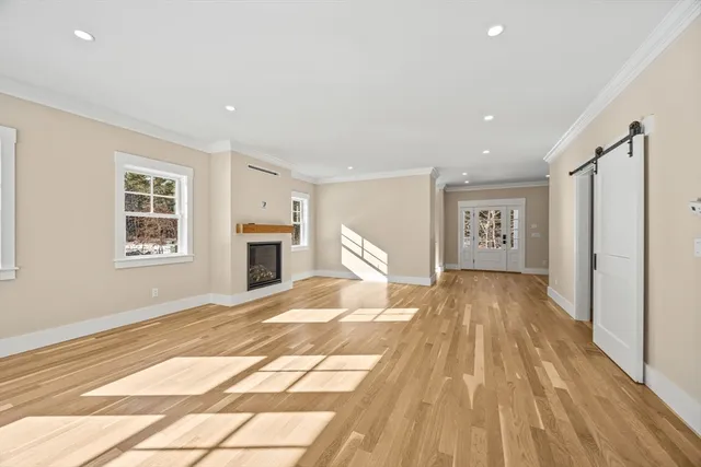 a view of a livingroom with wooden floor and a kitchen