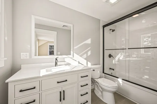 a bathroom with a sink a toilet and a mirror