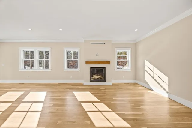 a view of an empty room with a fireplace and a window