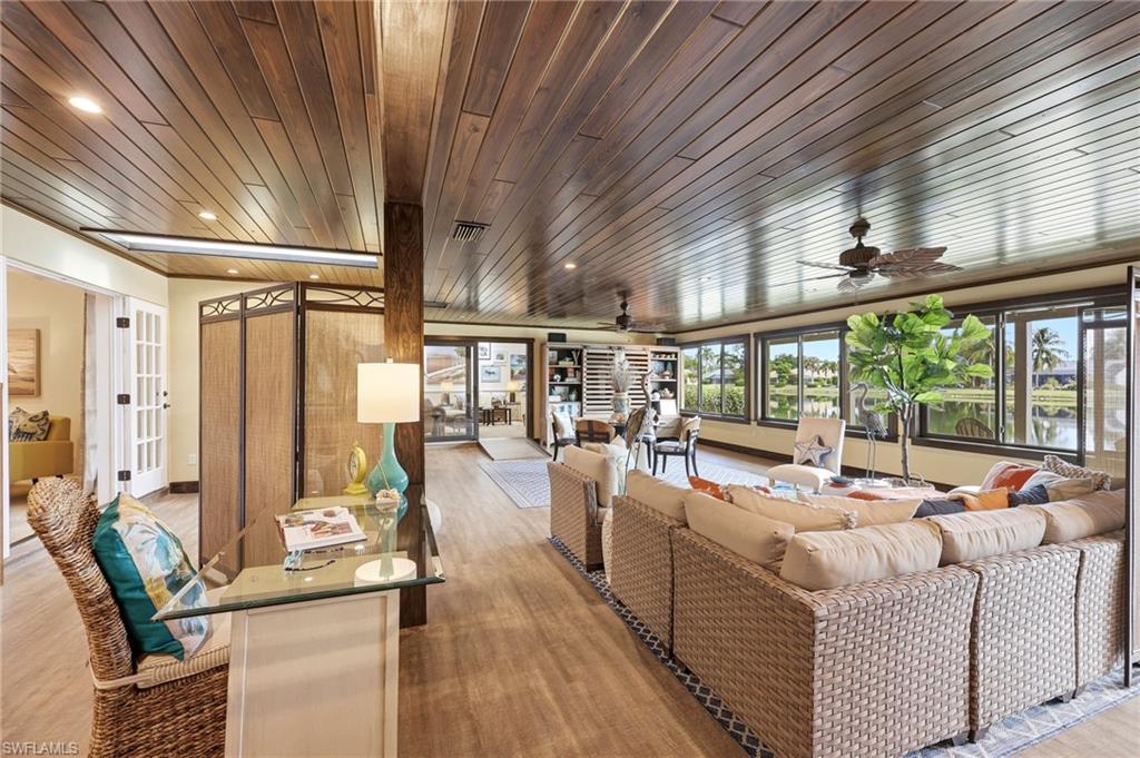 2274 Queens Way Naples, FL 34112 - Photo 11 of 32 a living room with furniture floor to ceiling window and outdoor seating