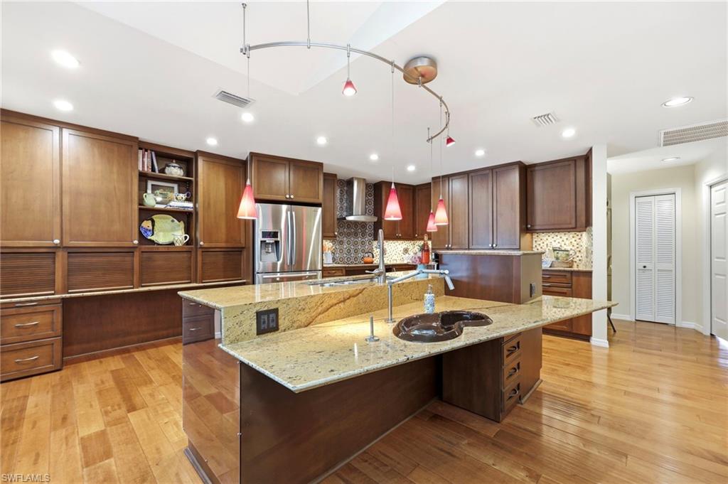 2274 Queens Way Naples, FL 34112 - Photo 6 of 32 a large kitchen with kitchen island a large counter top stainless steel appliances and cabinets