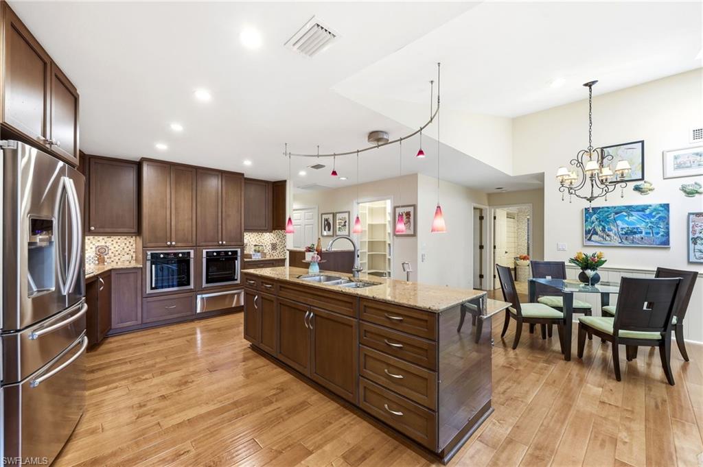 2274 Queens Way Naples, FL 34112 - Photo 7 of 32 a large kitchen with lots of counter space and stainless steel appliances