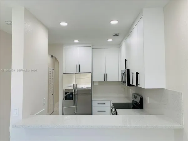 a kitchen with stainless steel appliances a refrigerator sink and microwave
