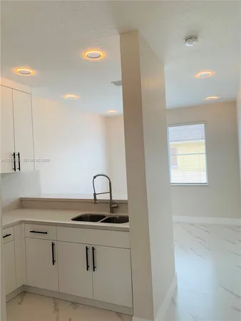 a view of a kitchen with a refrigerator and a sink
