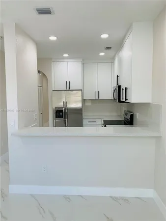 a kitchen with stainless steel appliances a refrigerator and microwave