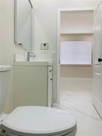 a white toilet sitting next to a shower