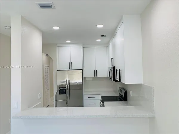 a kitchen with stainless steel appliances a refrigerator and a stove top oven