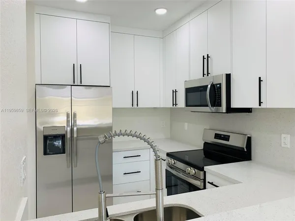 a kitchen with stainless steel appliances white cabinets and a stove a sink