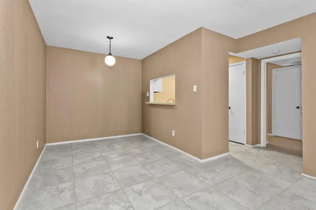 an empty room with closet and a chandelier fan