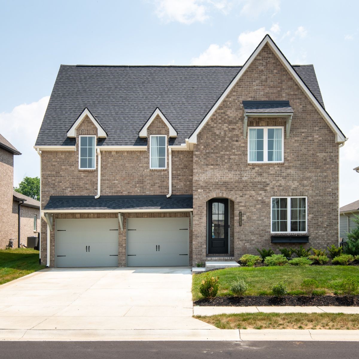 a front view of a house with a yard and garage