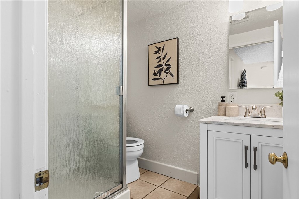 587 East 3rd Street Chico, CA 95928 - Photo 56 of 73 a bathroom with a granite countertop sink a toilet and a shower