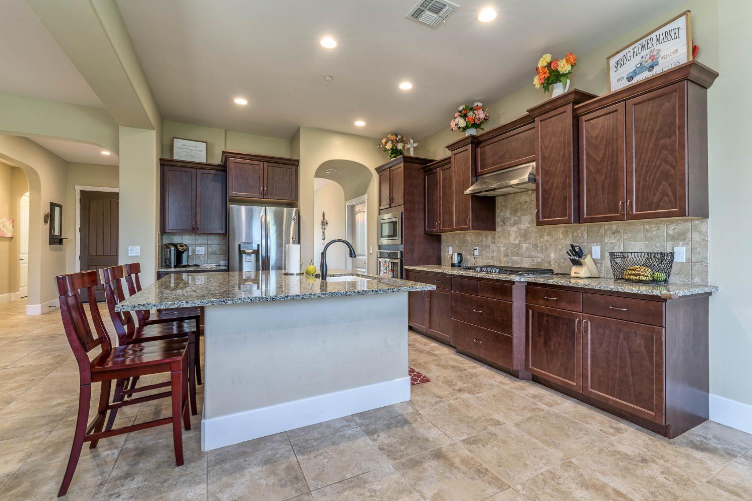 3230 Enterprise Avenue Clovis, CA 93619 - Photo 12 of 41 a kitchen with stainless steel appliances granite countertop a sink and a refrigerator