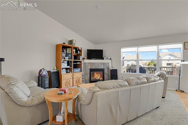 12237 Rio Secco Road Peyton, CO 80831 - Photo 6 of 45 Family room with fireplace and vaulted ceiling