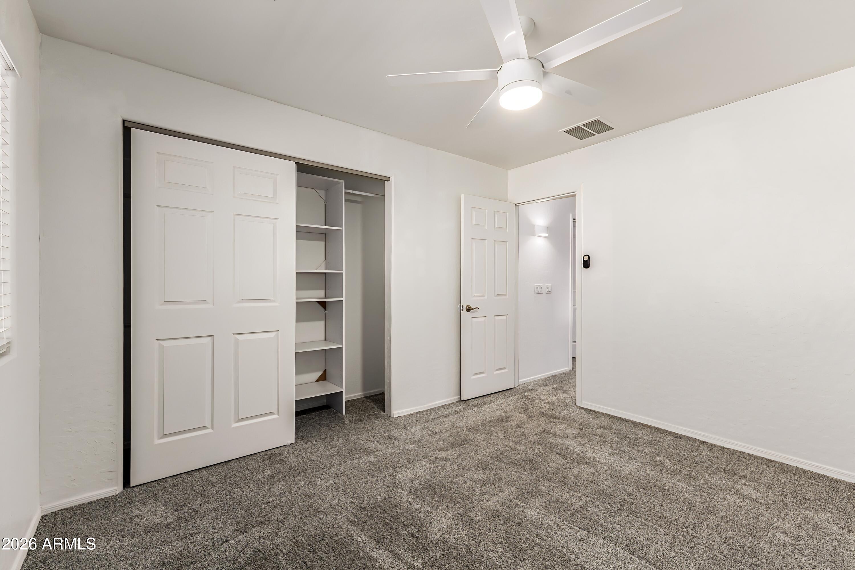 4208 South Sawmill Road Gilbert, AZ 85297 - Photo 29 of 46 an empty room with closet and a ceiling fan