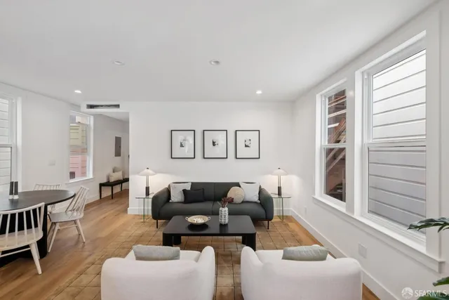 a kitchen with stainless steel appliances a dining table chairs and refrigerator