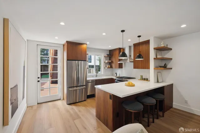 a kitchen with stainless steel appliances granite countertop a refrigerator and a sink