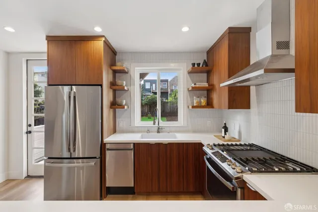 a kitchen with stainless steel appliances a sink stove and cabinets